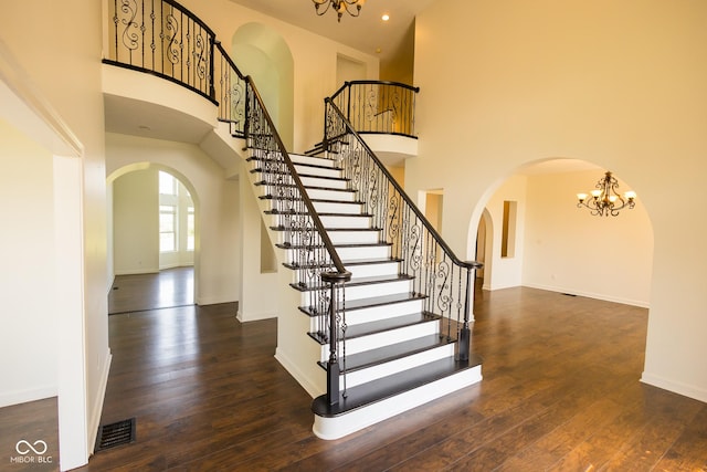 7493 W Lane Rd, Mccordsville, IN 46055 - stairs featuring arched walkways, a chandelier, a high ceiling, wood finished floors, and recessed lighting
