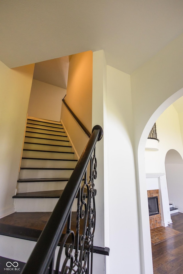 7493 W Lane Rd, Mccordsville, IN 46055 - stairway featuring a brick fireplace, wood finished floors, and arched walkways