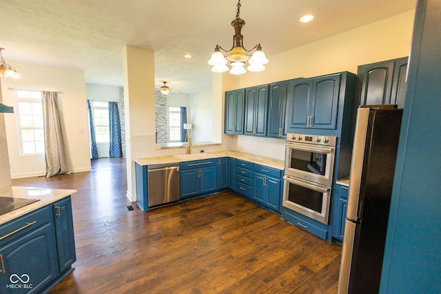 7493 W Lane Rd, Mccordsville, IN 46055 - kitchen with stainless steel appliances, a chandelier, blue cabinets, light countertops, and decorative light fixtures