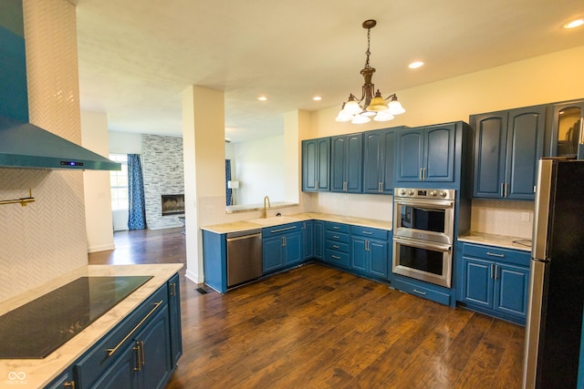 7493 W Lane Rd, Mccordsville, IN 46055 - kitchen with stainless steel appliances, wall chimney range hood, a chandelier, blue cabinets, and dark wood finished floors