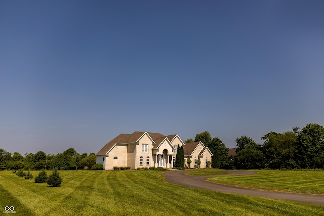 7493 W Lane Rd, Mccordsville, IN 46055 - french country style house with a front lawn, driveway, and stucco siding