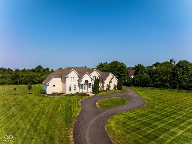 7493 W Lane Rd, Mccordsville, IN 46055 - view of front of house featuring a front lawn, stucco siding, and curved driveway