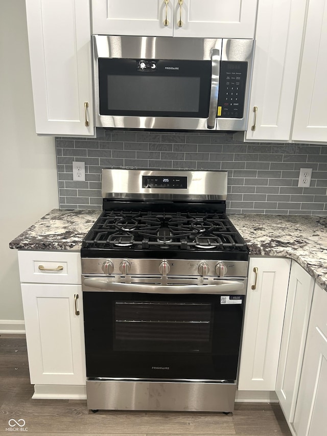 2631 Mcleay Dr, Indianapolis, IN 46220 - kitchen featuring appliances with stainless steel finishes, wood finished floors, white cabinets, and light stone countertops