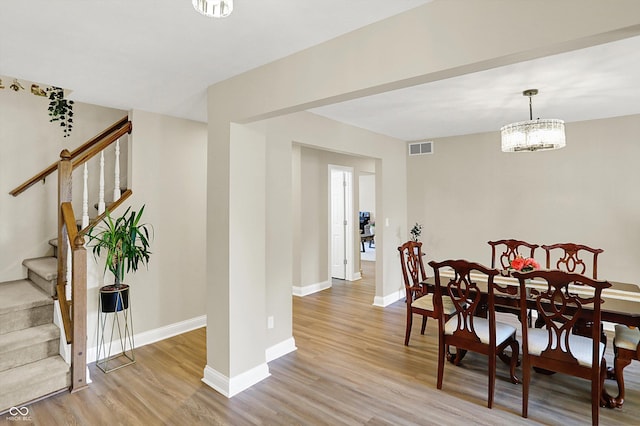 6050 Acorn Dr, Columbus, IN 47201 - dining room with light wood finished floors, stairway, and a chandelier