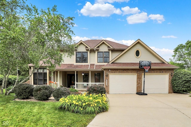 6050 Acorn Dr, Columbus, IN 47201 - view of front of house with driveway, a porch, a garage, and brick siding