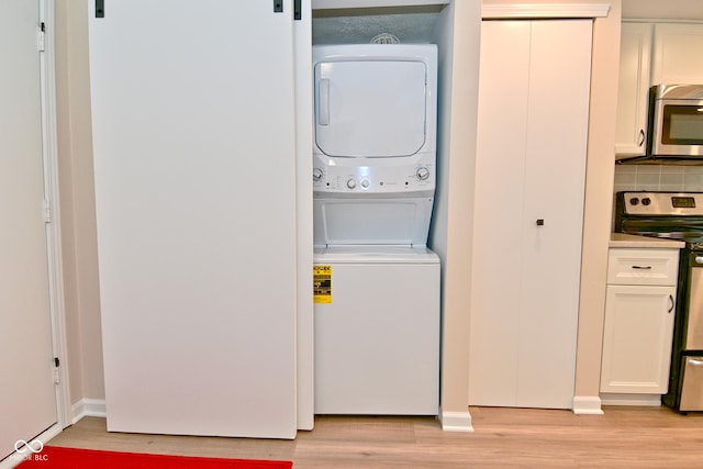 9477 Aberdare Dr N, Indianapolis, IN 46250 - washroom featuring estacked washer and dryer and light wood finished floors
