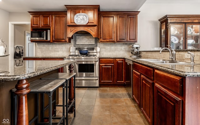 7743 Camelback Dr, Indianapolis, IN 46250 - kitchen featuring stainless steel appliances, backsplash, light stone countertops, dark tile patterned flooring, and a kitchen bar