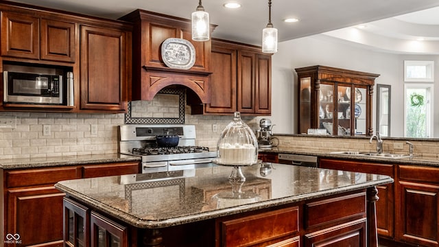 7743 Camelback Dr, Indianapolis, IN 46250 - kitchen featuring appliances with stainless steel finishes, backsplash, dark stone countertops, hanging light fixtures, and recessed lighting