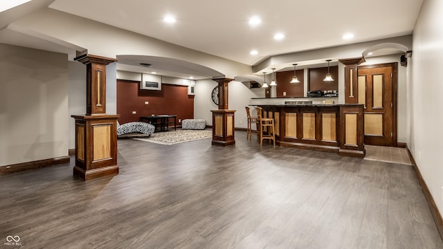 7743 Camelback Dr, Indianapolis, IN 46250 - indoor bar with dark wood finished floors, decorative columns, hanging light fixtures, arched walkways, and recessed lighting
