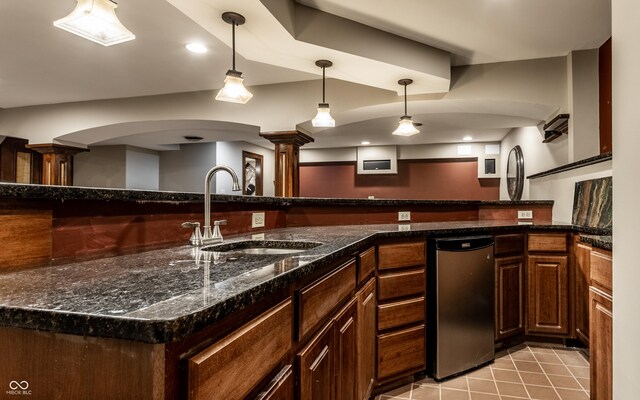 7743 Camelback Dr, Indianapolis, IN 46250 - kitchen with decorative light fixtures, arched walkways, ornate columns, dark stone counters, and recessed lighting