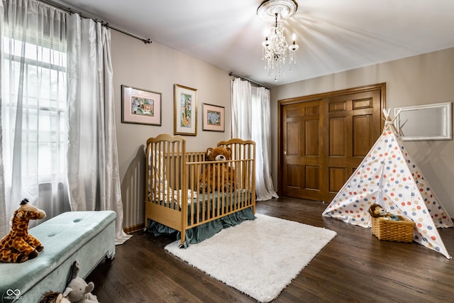 7743 Camelback Dr, Indianapolis, IN 46250 - bedroom with a chandelier, wood finished floors, and a crib
