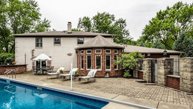 7743 Camelback Dr, Indianapolis, IN 46250 - rear view of house with a chimney, a patio area, brick siding, and a shingled roof