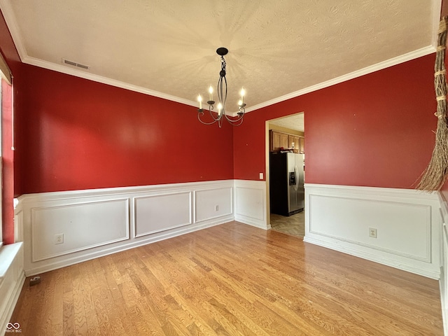 5571 Auburndale Dr, Bargersville, IN 46106 - unfurnished dining area with a chandelier, light wood-style floors, a wainscoted wall, and ornamental molding