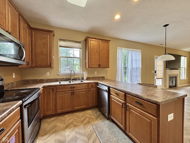 5571 Auburndale Dr, Bargersville, IN 46106 - kitchen with appliances with stainless steel finishes, brown cabinetry, a peninsula, recessed lighting, and hanging light fixtures