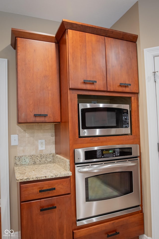 23119 Sonoma Ln, Cicero, IN 46034 - kitchen featuring appliances with stainless steel finishes, brown cabinets, backsplash, and light stone counters
