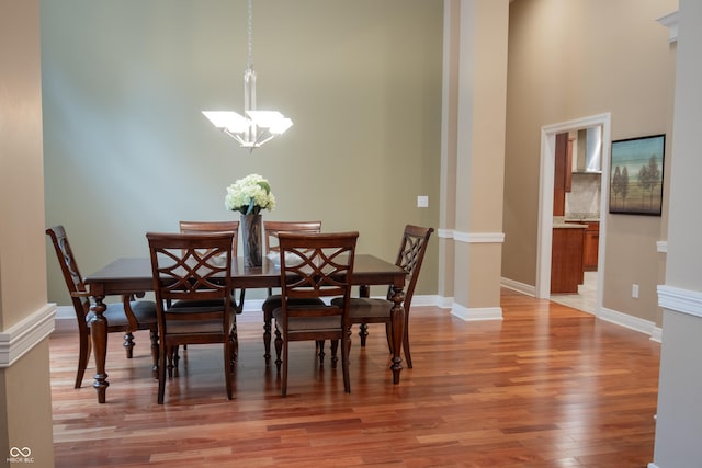 23119 Sonoma Ln, Cicero, IN 46034 - dining space with light wood-style floors, a chandelier, a high ceiling, and decorative columns