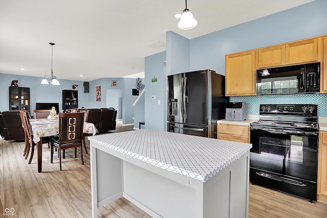 1571 N Creekwater Pass, Greenfield, IN 46140 - kitchen with black appliances, open floor plan, light countertops, light brown cabinets, and light wood-type flooring