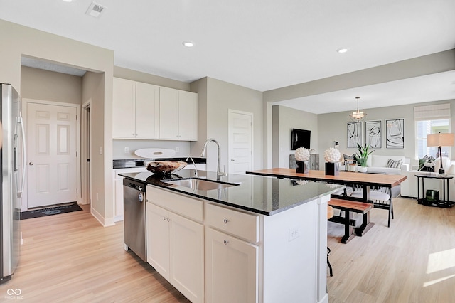 16876 Daly Dr, Noblesville, IN 46062 - kitchen featuring stainless steel appliances, light wood-style flooring, white cabinetry, a center island with sink, and recessed lighting