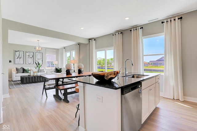 16876 Daly Dr, Noblesville, IN 46062 - kitchen with stainless steel dishwasher, light wood-style floors, white cabinetry, a kitchen island with sink, and dark countertops