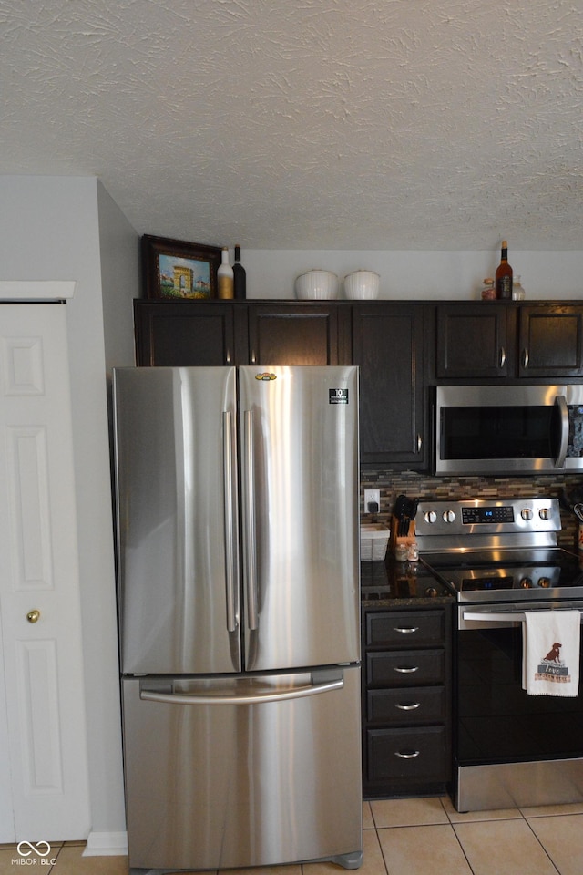 12389 Titans Dr, Fishers, IN 46037 - kitchen with appliances with stainless steel finishes, light tile patterned flooring, and a textured ceiling