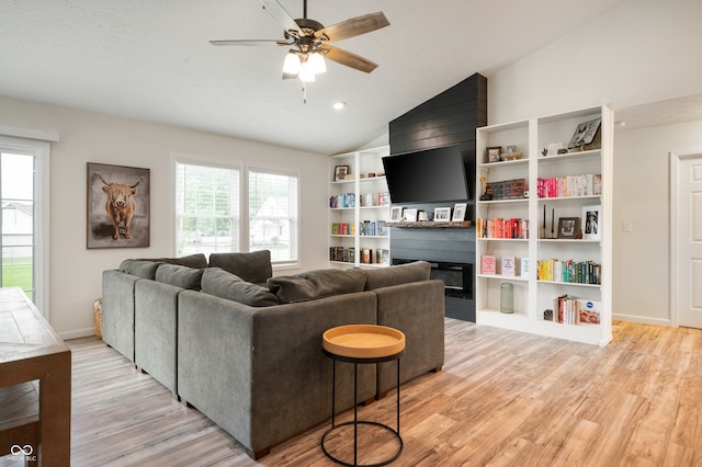 284 E Silver St, Knightstown, IN 46148 - living area with light wood finished floors, a fireplace, ceiling fan, lofted ceiling, and a textured ceiling