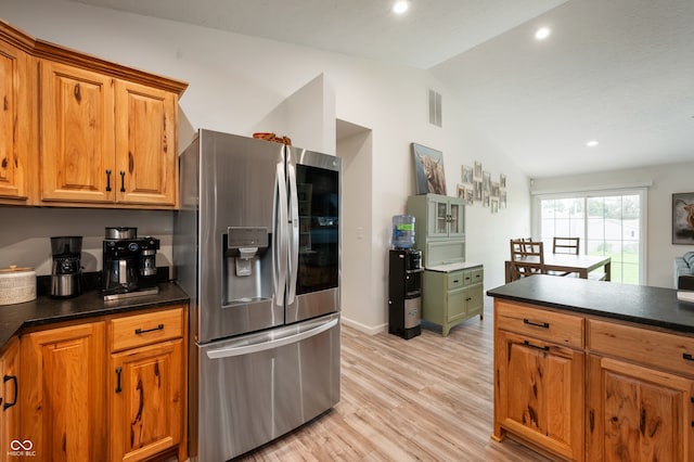 284 E Silver St, Knightstown, IN 46148 - kitchen featuring stainless steel fridge, vaulted ceiling, dark countertops, light wood-style flooring, and brown cabinets