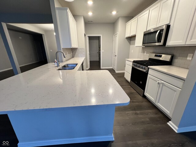 6729 Birmingham Ave, Mccordsville, IN 46055 - kitchen with stainless steel appliances, a peninsula, white cabinetry, backsplash, and light stone counters
