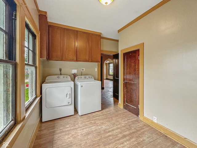 1011 W 7th St, Anderson, IN 46016 - laundry area featuring cabinet space, washer and dryer, light wood finished floors, and arched walkways