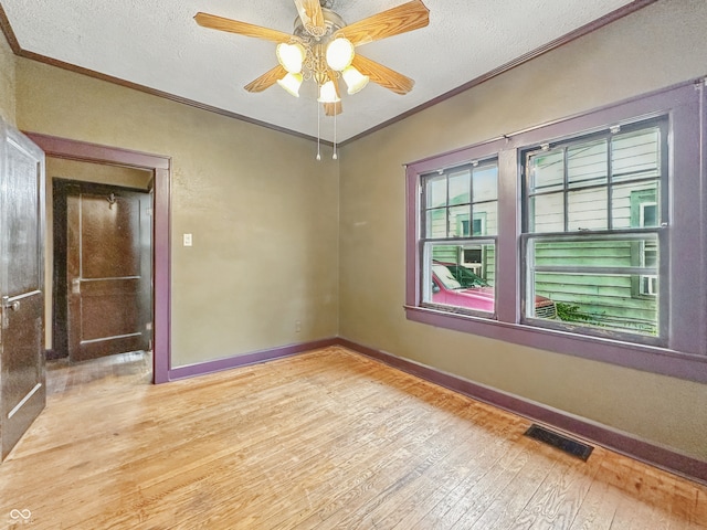 1011 W 7th St, Anderson, IN 46016 - empty room with ornamental molding, light wood-type flooring, a textured ceiling, and ceiling fan