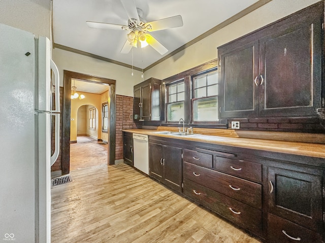 1011 W 7th St, Anderson, IN 46016 - kitchen featuring white appliances, butcher block counters, dark brown cabinets, arched walkways, and light wood-style floors