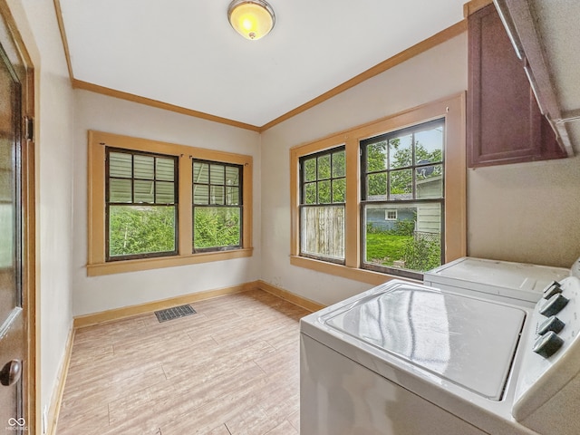 1011 W 7th St, Anderson, IN 46016 - laundry room with cabinet space, washer and dryer, light wood-style floors, and crown molding