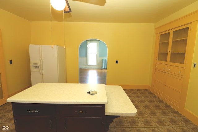 611 E Wabash Ave, Crawfordsville, IN 47933 - kitchen featuring white refrigerator with ice dispenser, radiator heating unit, arched walkways, ceiling fan, and light countertops