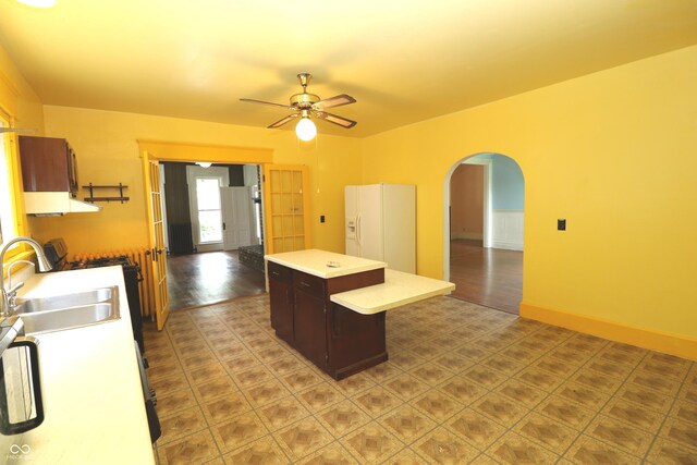 611 E Wabash Ave, Crawfordsville, IN 47933 - kitchen featuring a kitchen island, arched walkways, ceiling fan, light countertops, and white refrigerator with ice dispenser
