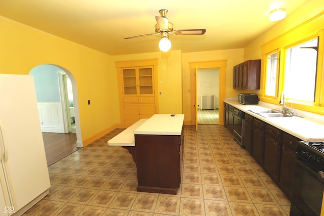 611 E Wabash Ave, Crawfordsville, IN 47933 - kitchen featuring radiator heating unit, arched walkways, a center island, light countertops, and ceiling fan