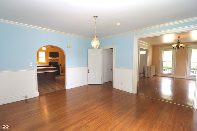 611 E Wabash Ave, Crawfordsville, IN 47933 - unfurnished dining area with radiator, arched walkways, a chandelier, wood finished floors, and wainscoting
