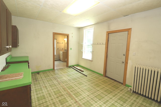 611 E Wabash Ave, Crawfordsville, IN 47933 - empty room with radiator heating unit, a drop ceiling, and light flooring