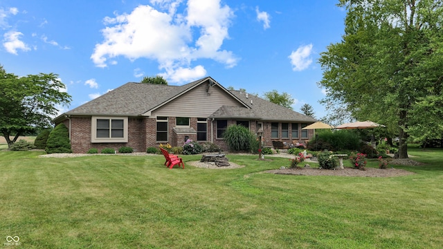 8818 Mathews Rd, Indianapolis, IN 46259 - view of front of home featuring a fire pit, brick siding, a front yard, and a shingled roof