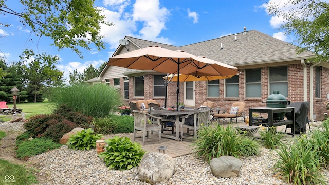 8818 Mathews Rd, Indianapolis, IN 46259 - back of property featuring roof with shingles, brick siding, a patio, and outdoor dining area