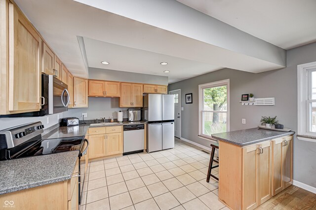 6143 Schoolwood Dr, Indianapolis, IN 46224 - kitchen featuring stainless steel appliances, light brown cabinets, recessed lighting, a kitchen breakfast bar, and dark countertops