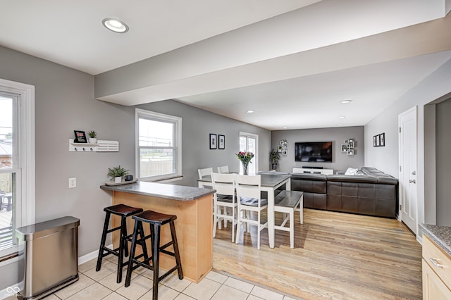 6143 Schoolwood Dr, Indianapolis, IN 46224 - kitchen featuring a breakfast bar area, light tile patterned floors, recessed lighting, and a peninsula