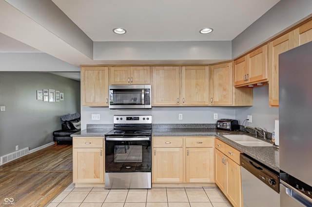 6143 Schoolwood Dr, Indianapolis, IN 46224 - kitchen with appliances with stainless steel finishes, light brown cabinetry, dark countertops, and recessed lighting