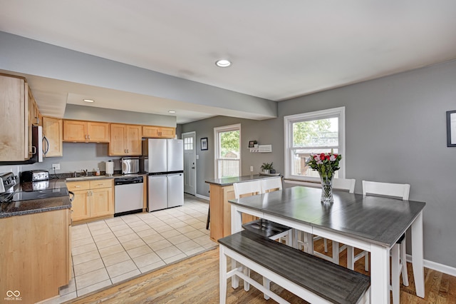 6143 Schoolwood Dr, Indianapolis, IN 46224 - kitchen with appliances with stainless steel finishes, light brown cabinetry, dark countertops, recessed lighting, and light wood finished floors