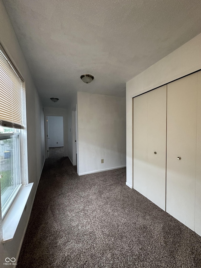 12639 Justice Xing, Fishers, IN 46037 - unfurnished bedroom with dark carpet, a textured ceiling, and a closet