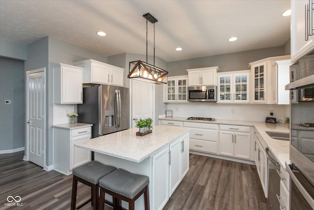 10334 Deercrest Ln, Indianapolis, IN 46239 - kitchen with appliances with stainless steel finishes, dark wood finished floors, a kitchen island, white cabinetry, and recessed lighting