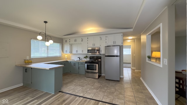 3019 E Berwyn St, Indianapolis, IN 46203 - kitchen featuring stainless steel appliances, a raised ceiling, a peninsula, light countertops, and pendant lighting