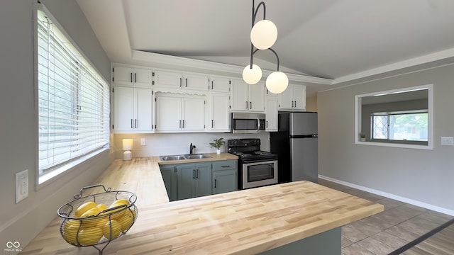3019 E Berwyn St, Indianapolis, IN 46203 - kitchen with appliances with stainless steel finishes, vaulted ceiling, butcher block counters, white cabinetry, and hanging light fixtures