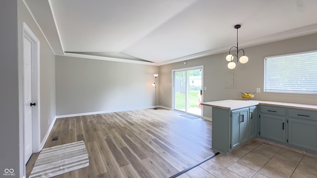 3019 E Berwyn St, Indianapolis, IN 46203 - kitchen featuring vaulted ceiling, light countertops, light wood-style flooring, open floor plan, and hanging light fixtures