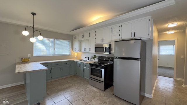3019 E Berwyn St, Indianapolis, IN 46203 - kitchen with appliances with stainless steel finishes, a peninsula, light countertops, light tile patterned floors, and hanging light fixtures