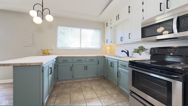 3019 E Berwyn St, Indianapolis, IN 46203 - kitchen featuring stainless steel appliances, a peninsula, white cabinets, wooden counters, and pendant lighting