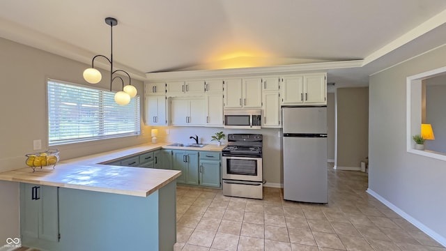 3019 E Berwyn St, Indianapolis, IN 46203 - kitchen featuring stainless steel appliances, light countertops, a peninsula, decorative light fixtures, and vaulted ceiling